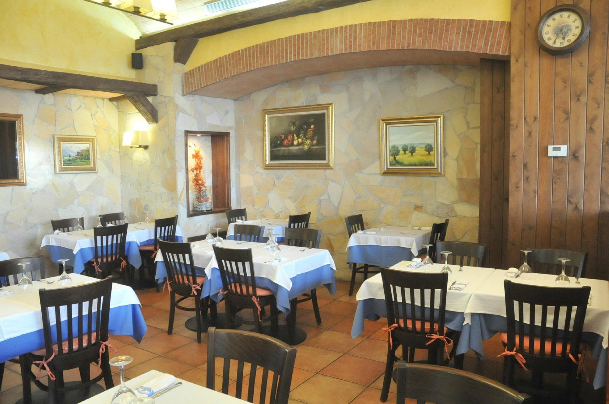 Comedor de El Rebost de Montigalà, con paredes de piedra y mesas puestas
